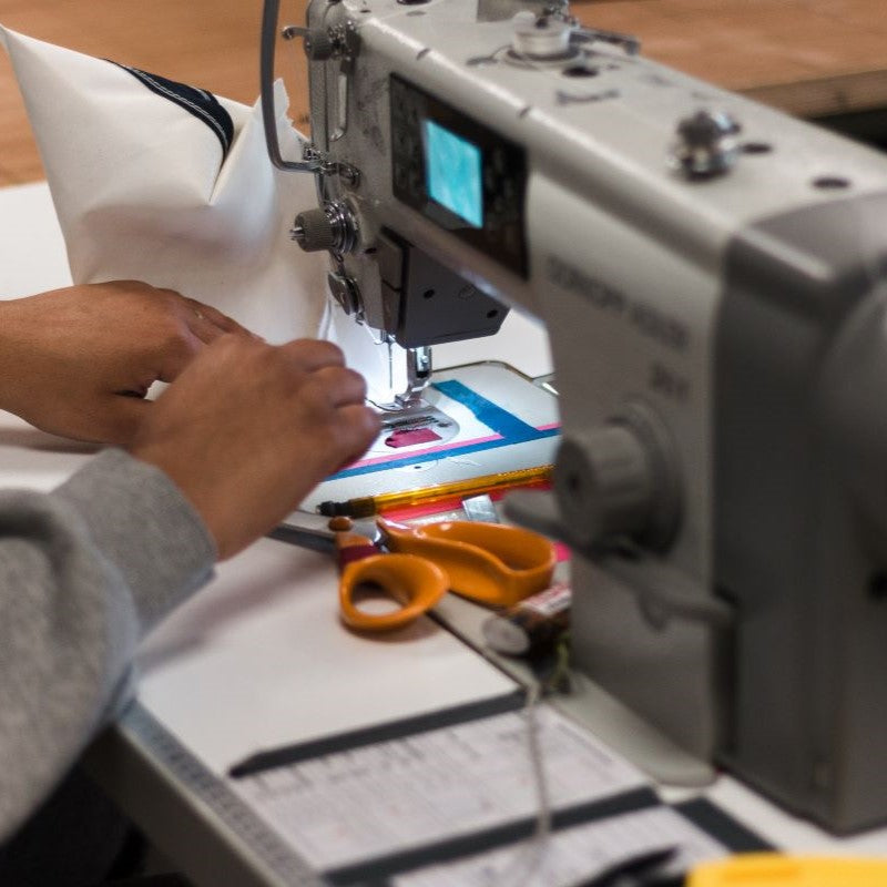 Riparazione artigianale di una borsa realizzata con vele di barche riciclate: il know-how locale presso il laboratorio Les Toiles du Large di La Ciotat